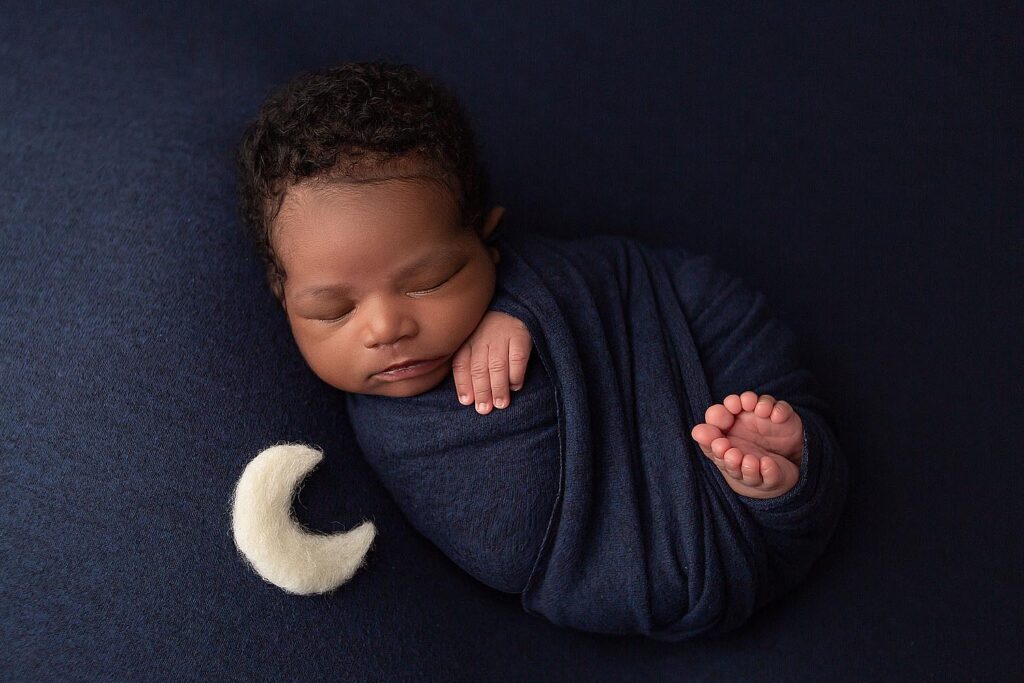 newborn-boy-on-blue-backdrop-photo