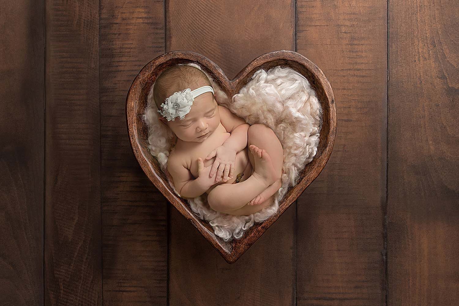 newborn baby in wood heart