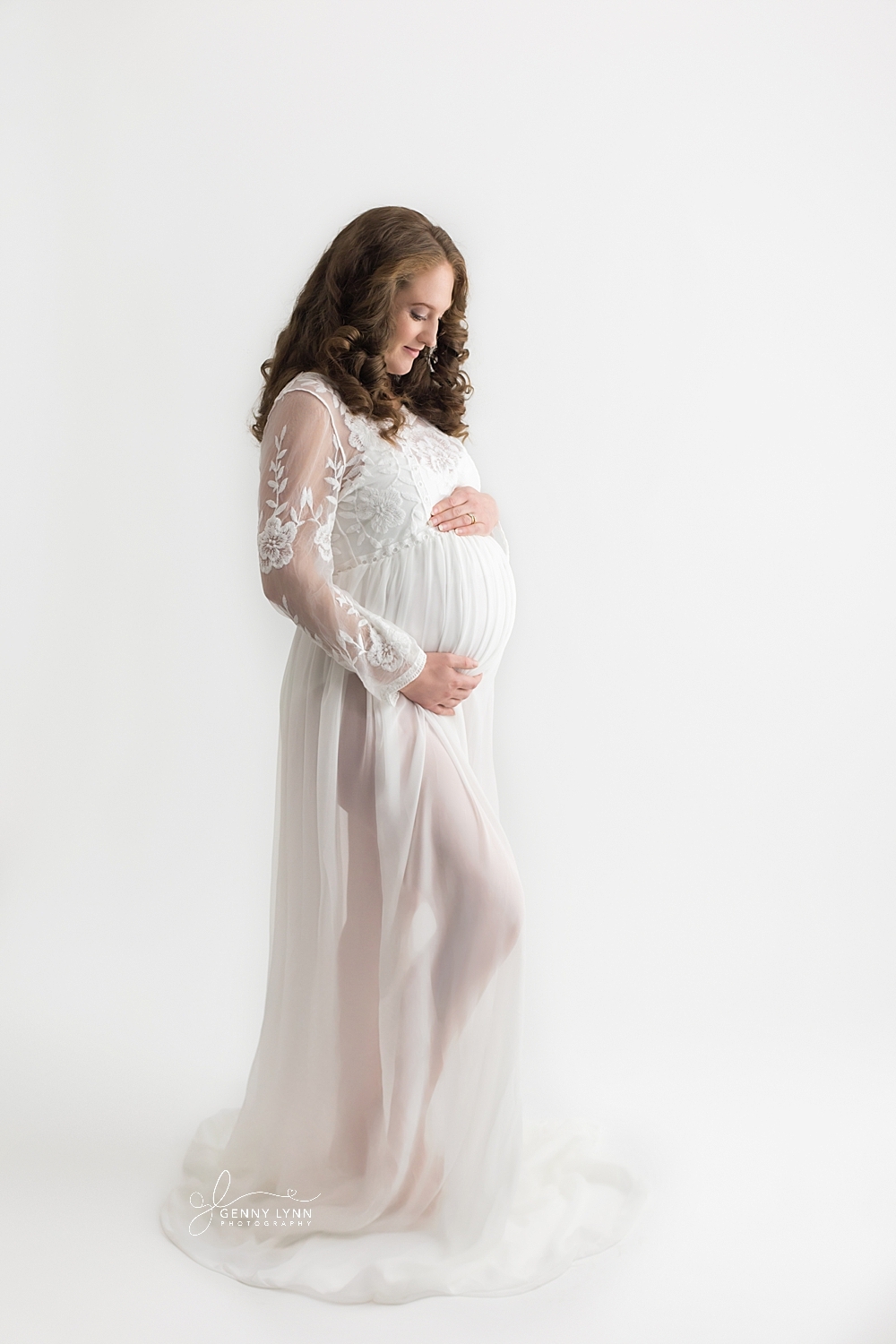 pregnant woman in white maternity gown on white backdrop for photoshoot in pembroke pines, fl