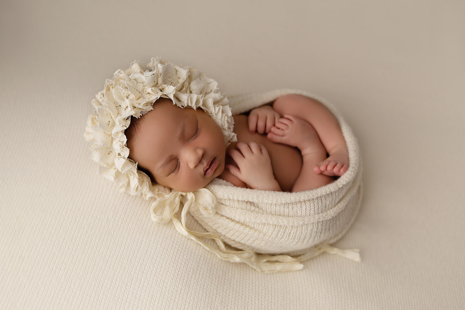 baby photographed on cream with bonnet in cooper city, fl