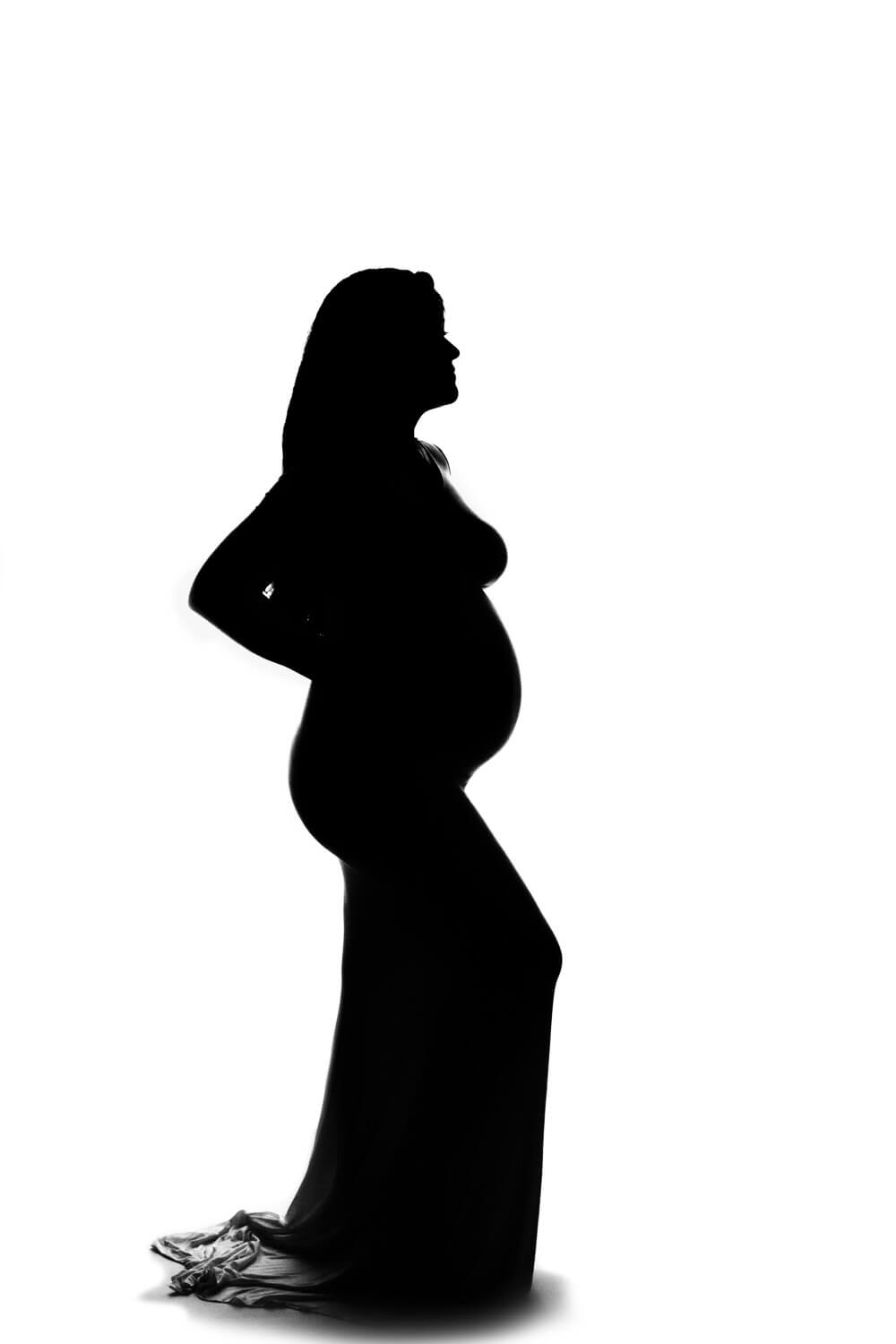 silhouette of a pregnant woman posing for maternity photo