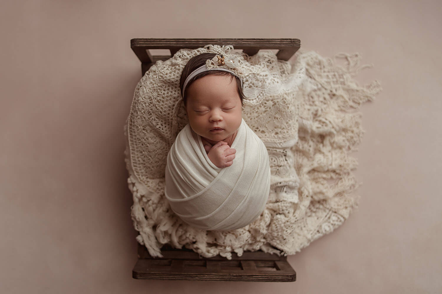 newborn girl on lace bed