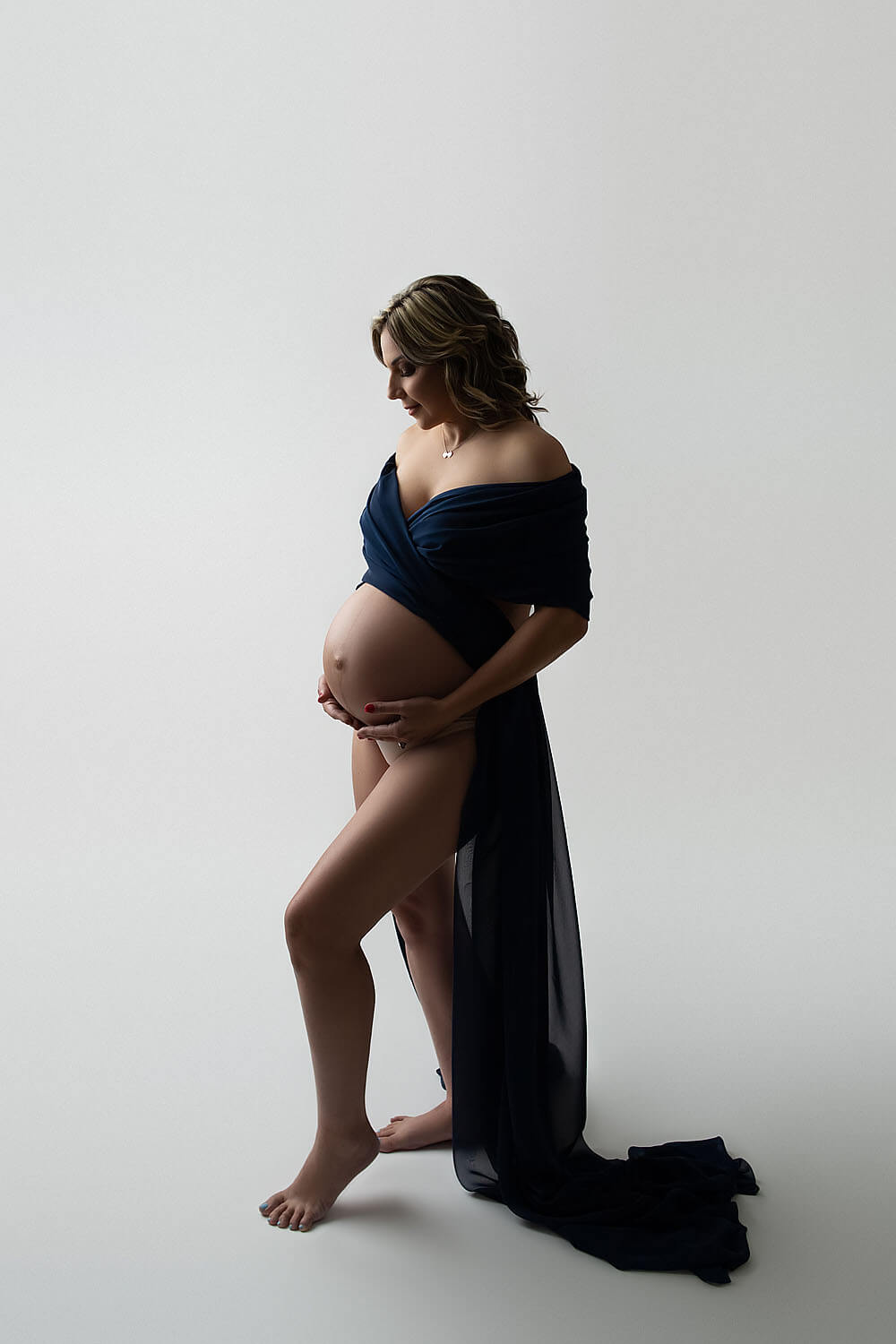 pregnant woman holding belly wrapped with fabric