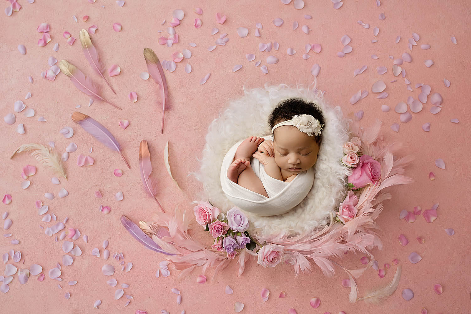 newborn baby girl in flower nest