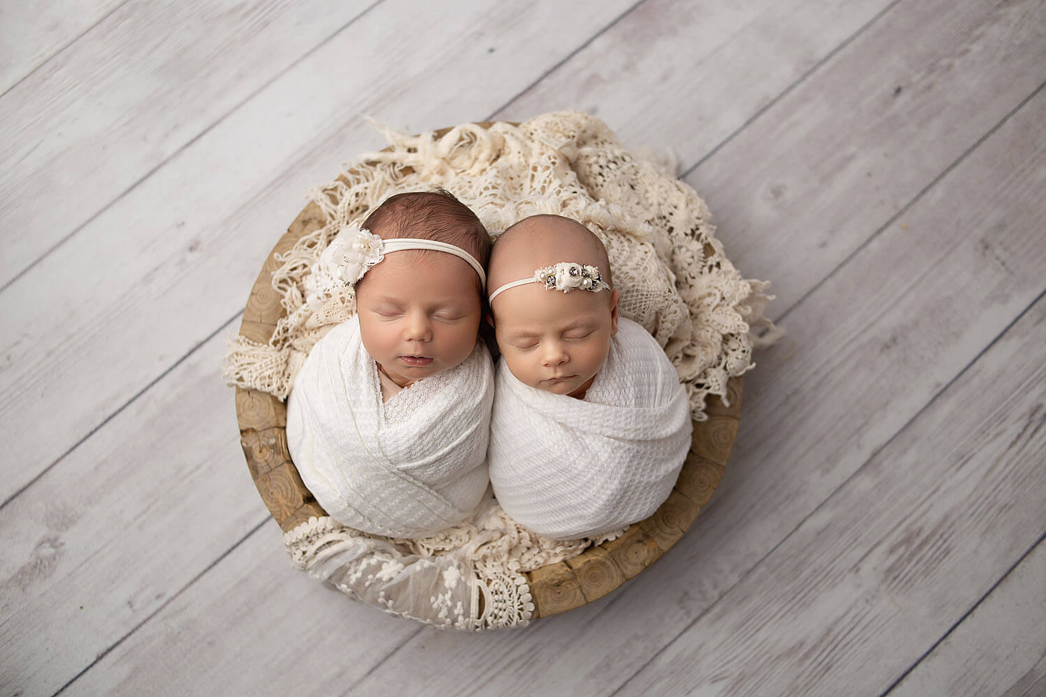 twin newborn baby girls in a bowl