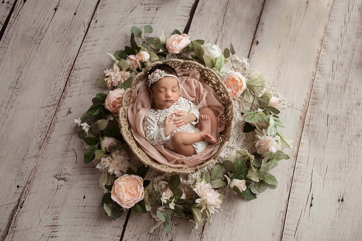 baby posed in a basket with flowers for newborn session in coral springs, FL