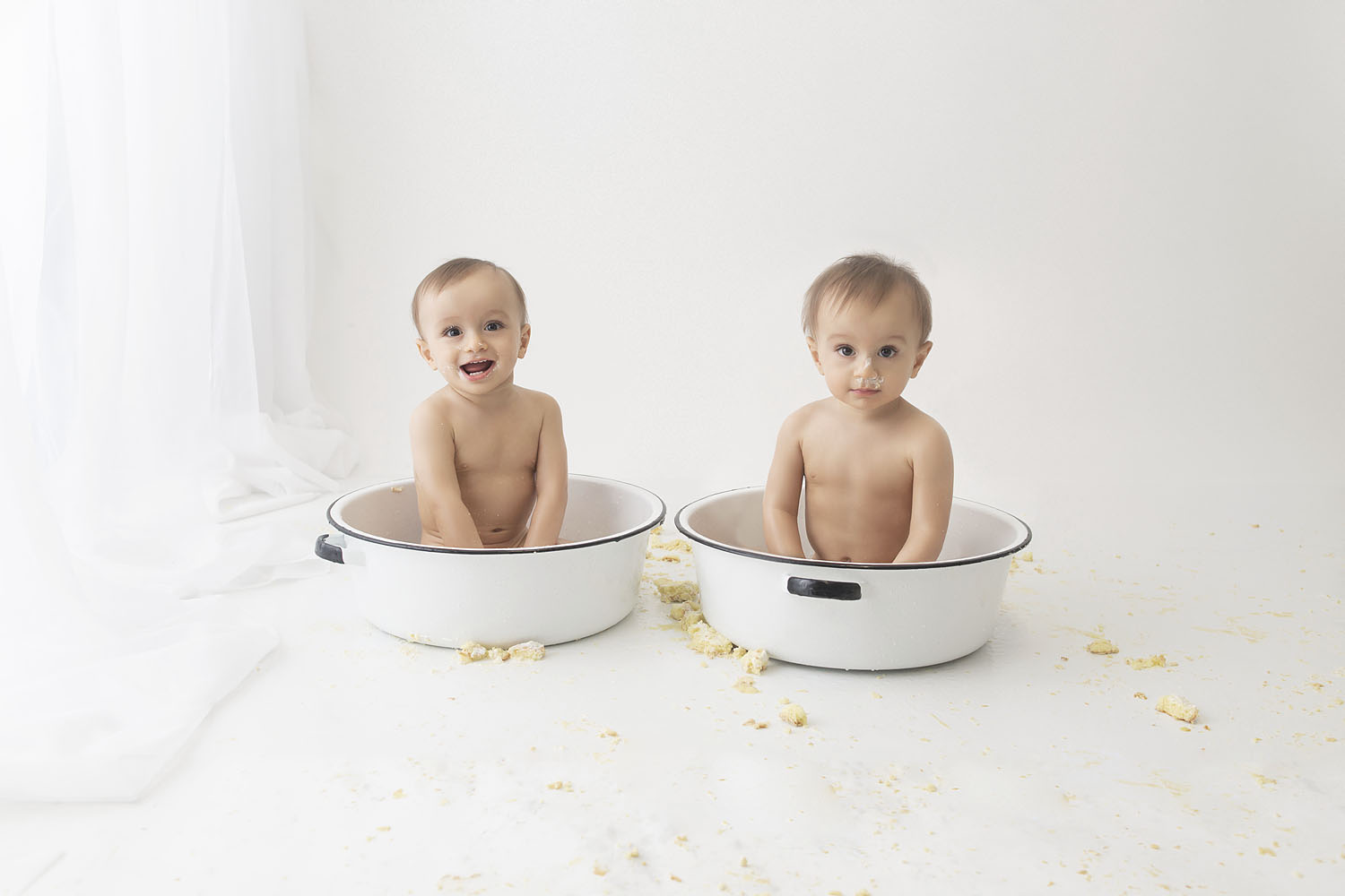 twin boys in a bowl at their first birthday cake smash session in hollywood fl