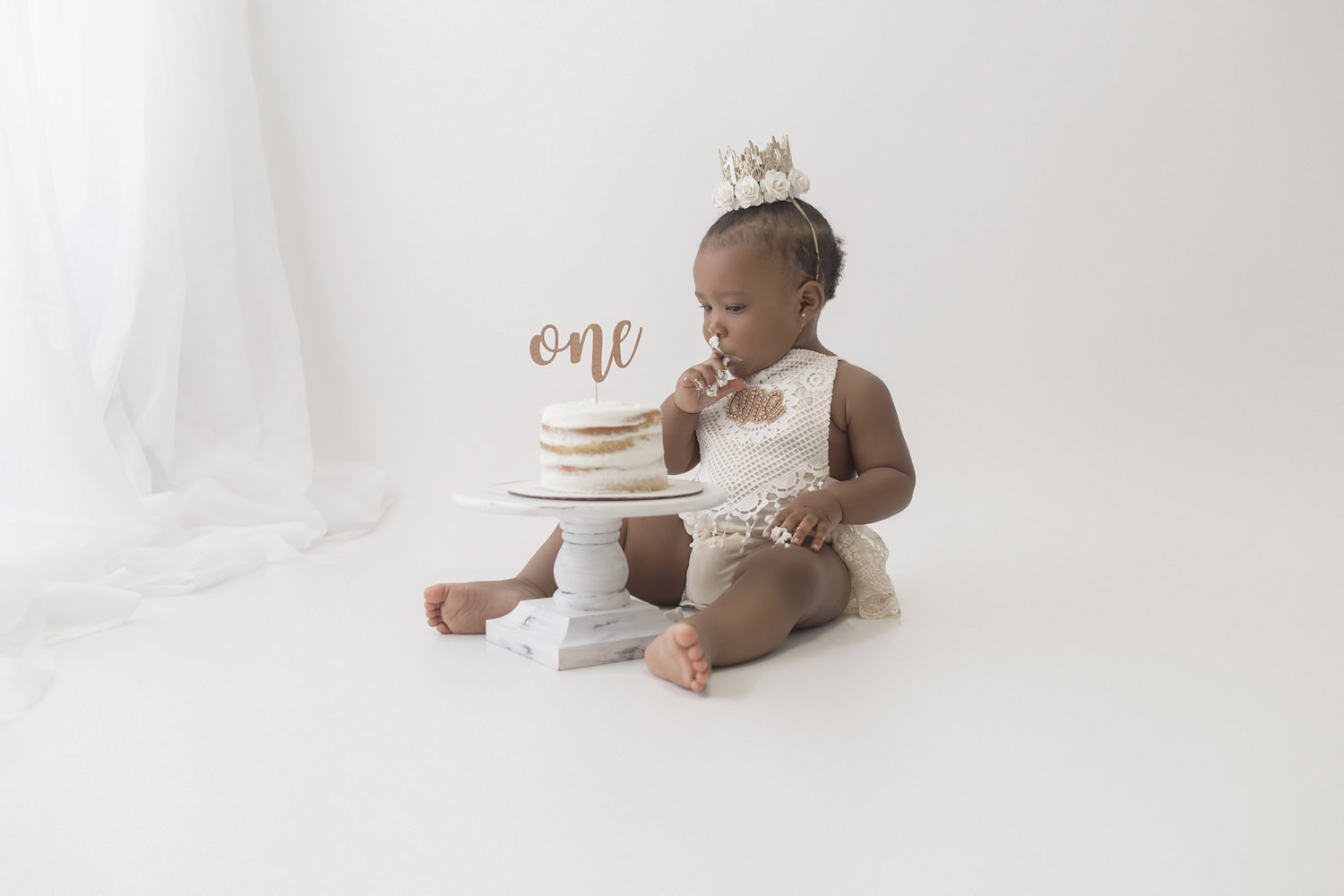 baby eating cake for her one year milestone cake smash photography session in parkland, fl