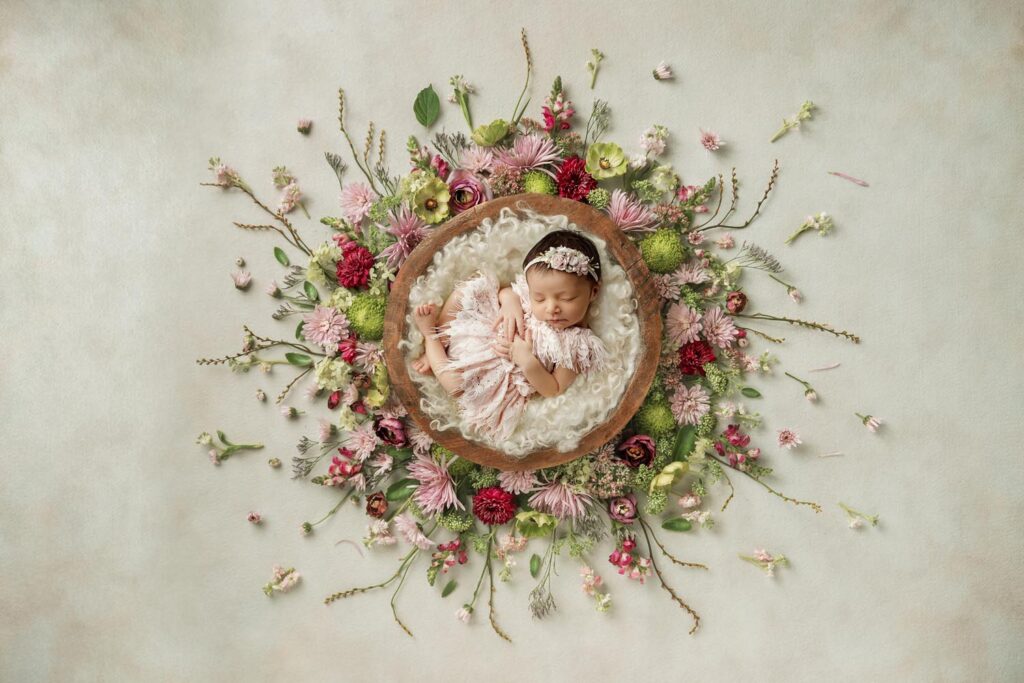 baby girl posed in a bowl with flowers at at newborn photography studio in the Aventura and Miami fl area