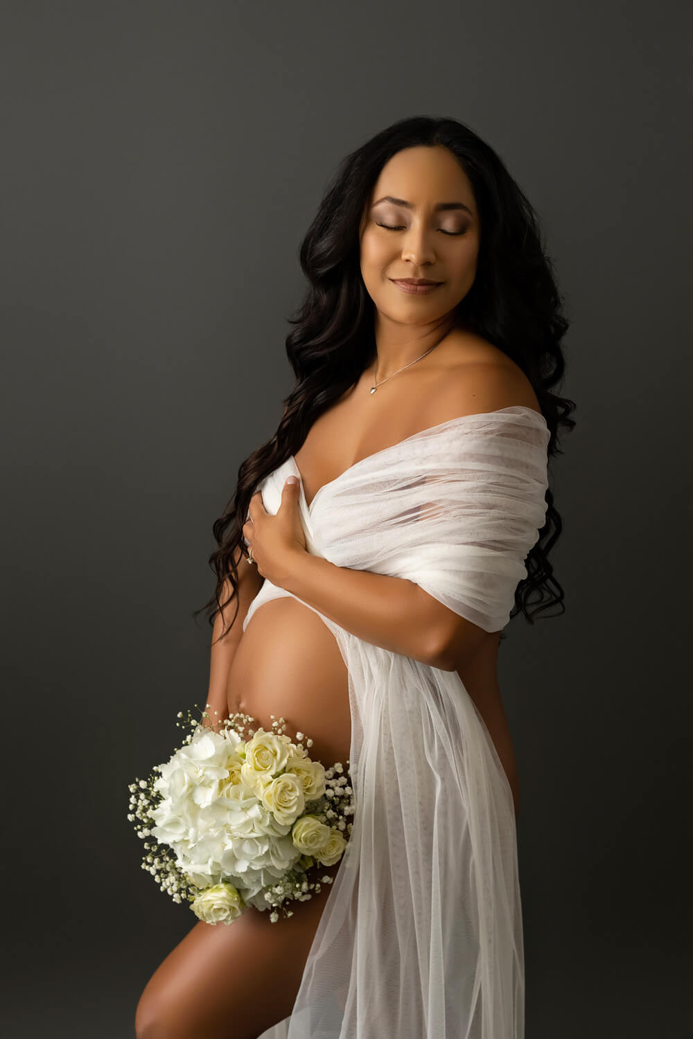 pregnant woman holding flowers for maternity pictures