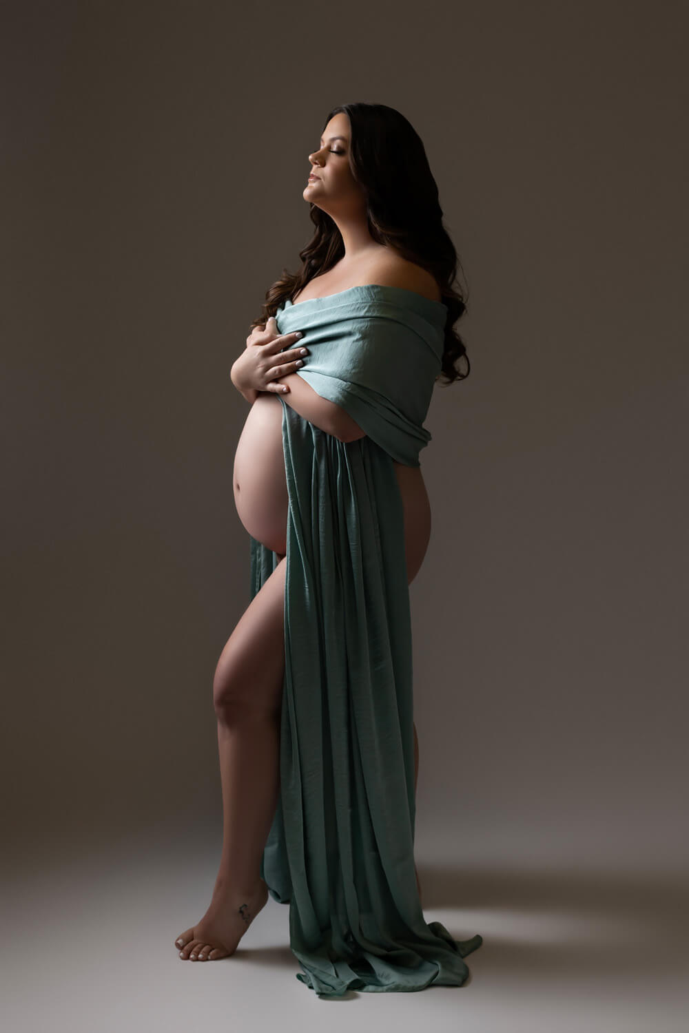 woman posed with draped fabric in maternity photoshoot